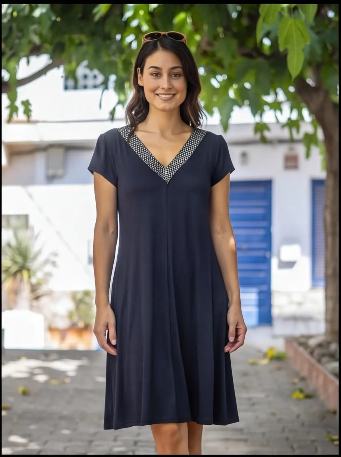 Vestido preto em crepe com decote recortado e bolsos.